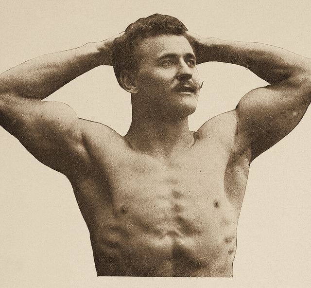 Eugen Sandow, el padre del culturismo, con los brazos detrás de la cabeza